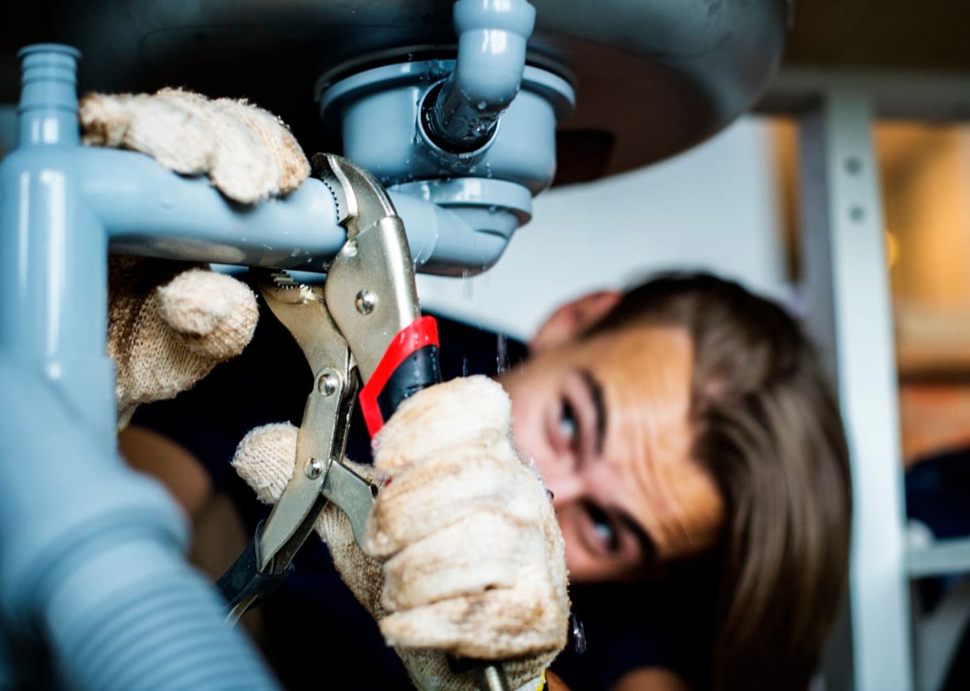 Handwerker repariert einen undichten Siphon unter dem Waschbecken